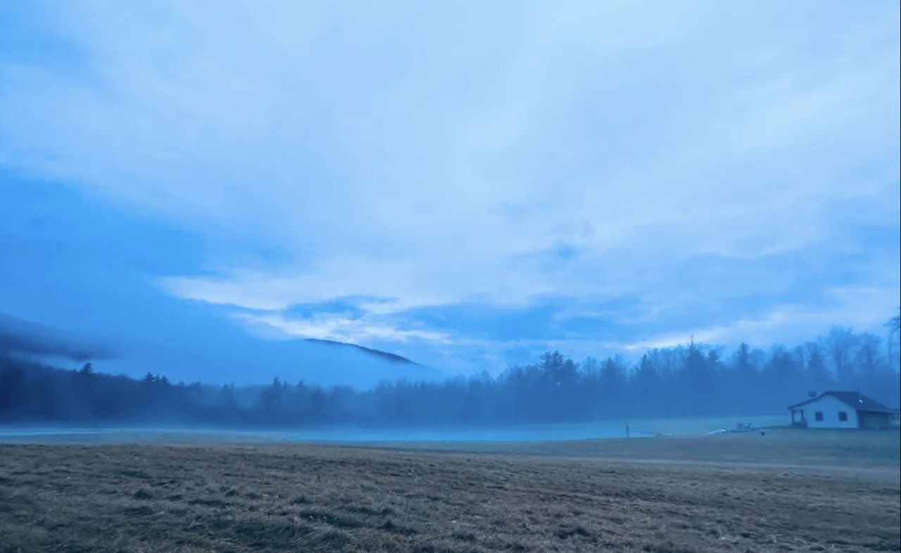 Fog over a Vermont field, a lone cabin at the treeline