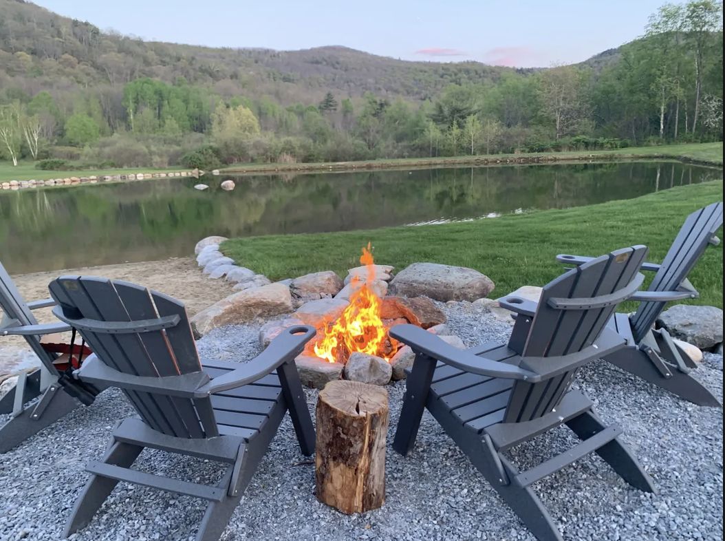 Firepit and chairs by the pond at dusk