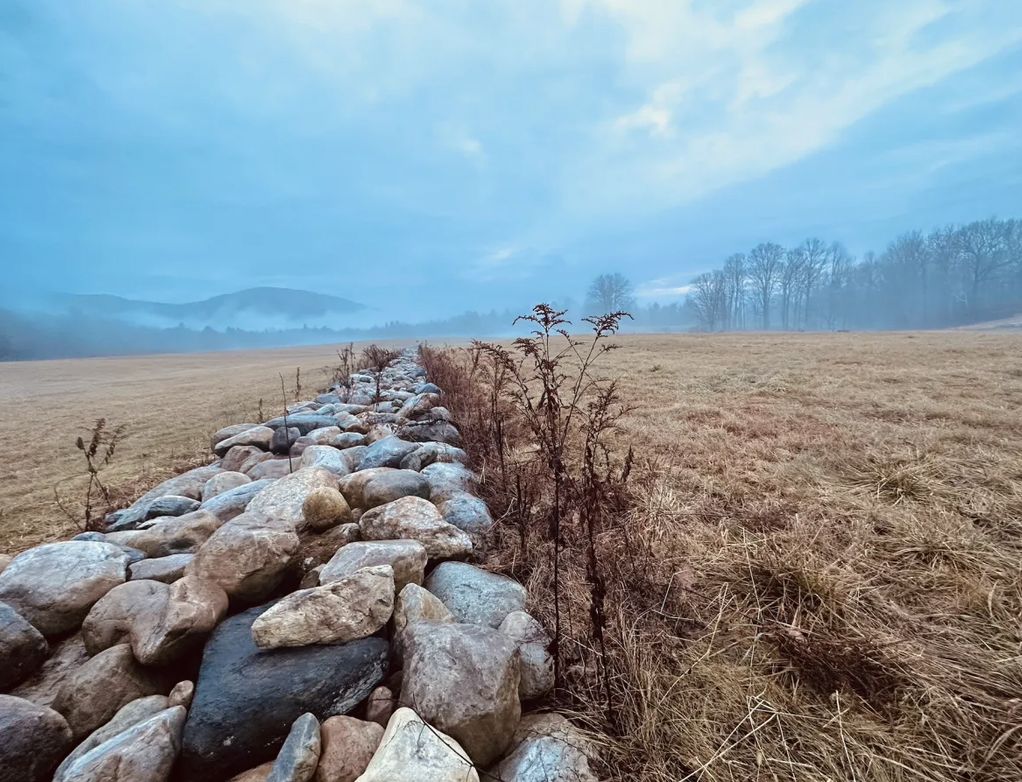 Fieldstone wall running into fog